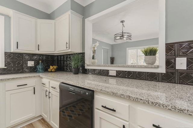 kitchen featuring light stone counters, tasteful backsplash, white cabinetry, light wood-type flooring, and dishwasher