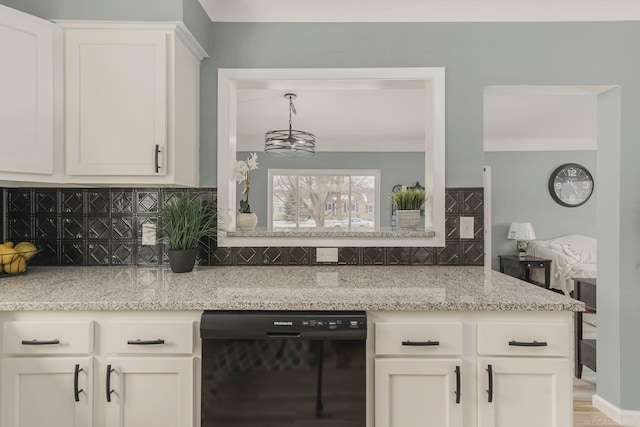 kitchen with black dishwasher, tasteful backsplash, white cabinetry, and light stone countertops