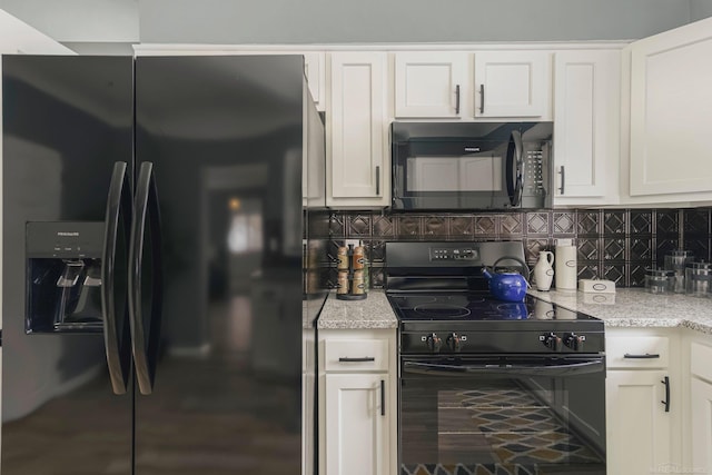 kitchen featuring light stone counters, white cabinetry, backsplash, and black appliances