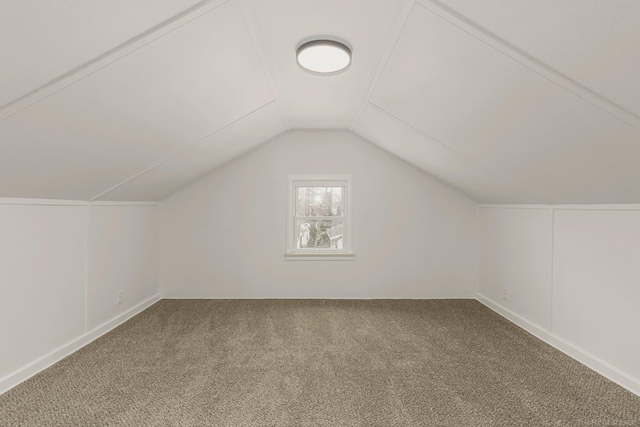 additional living space featuring carpet floors and vaulted ceiling