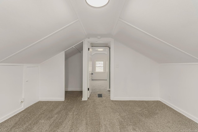 bonus room with carpet, visible vents, and vaulted ceiling