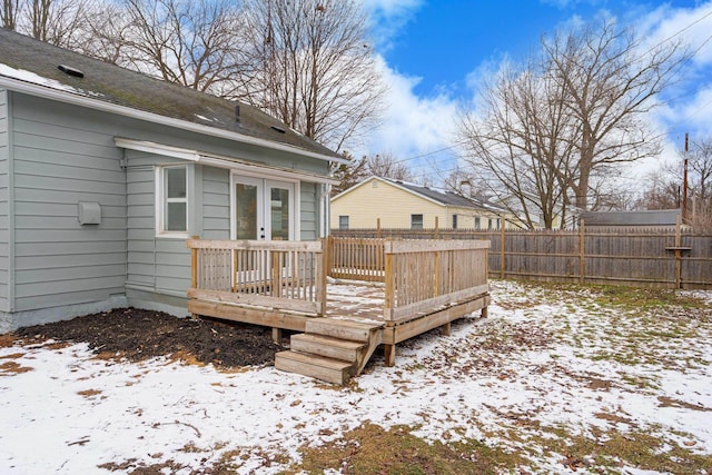 snow covered deck with fence and french doors