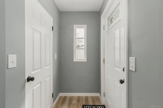 doorway with light wood-type flooring and baseboards