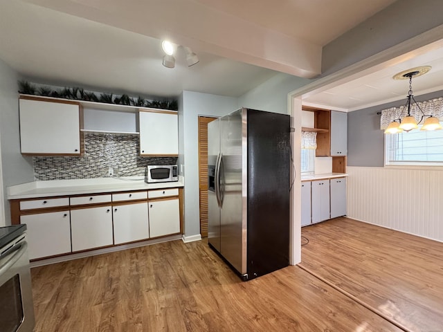 kitchen with stainless steel appliances, light wood finished floors, light countertops, and white cabinetry