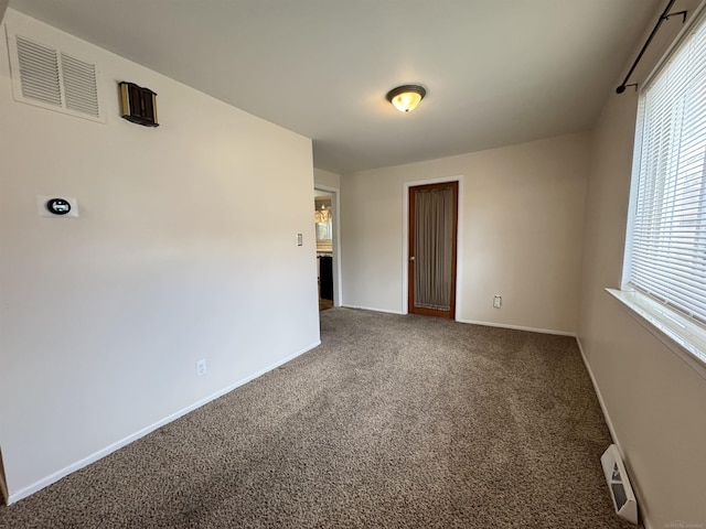 spare room featuring visible vents, baseboards, and carpet flooring