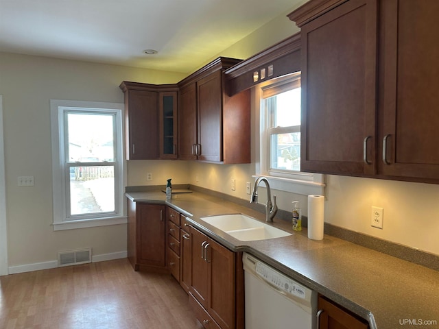 kitchen featuring a wealth of natural light, white dishwasher, visible vents, and a sink