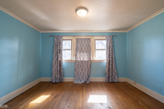 unfurnished room featuring ornamental molding, wood-type flooring, and baseboards