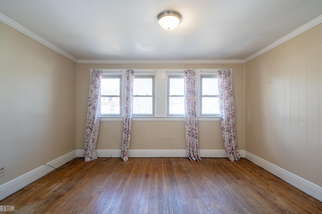 empty room with plenty of natural light, baseboards, wood-type flooring, and ornamental molding