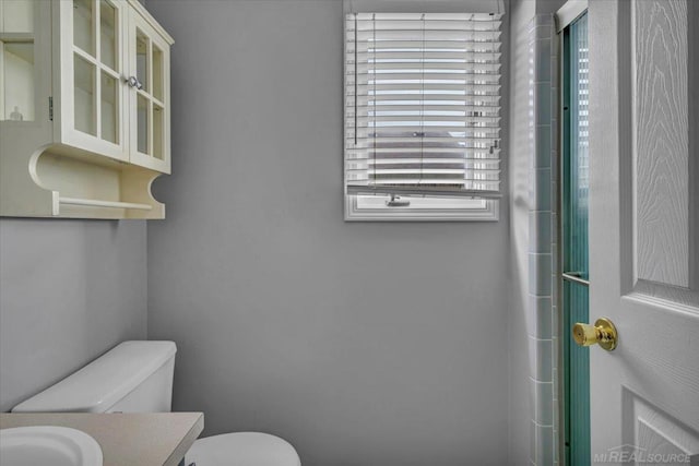 bathroom featuring an enclosed shower, vanity, and toilet