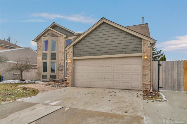 view of front of property with an attached garage, fence, concrete driveway, and brick siding