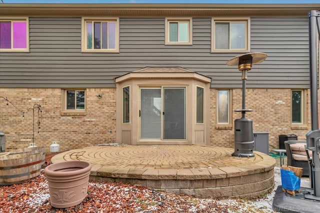 back of property featuring brick siding