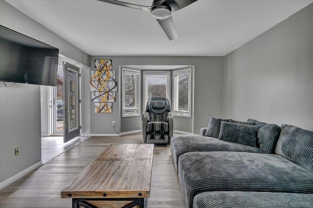 living room with ceiling fan, baseboards, and hardwood / wood-style flooring