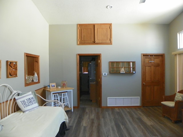 interior space with a towering ceiling, visible vents, and wood finished floors