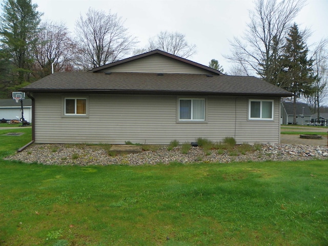 view of home's exterior featuring roof with shingles, a lawn, and a wall mounted air conditioner