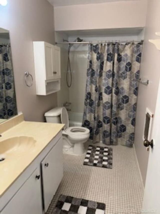 bathroom featuring vanity, shower / bath combo with shower curtain, tile patterned flooring, and toilet