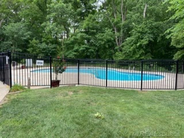 pool with fence and a lawn