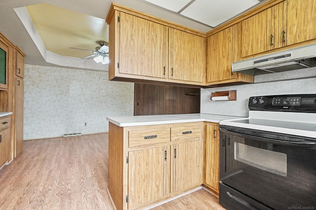 kitchen with visible vents, electric stove, light countertops, light wood-type flooring, and under cabinet range hood