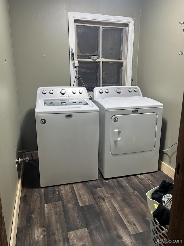 clothes washing area featuring laundry area, baseboards, separate washer and dryer, and wood finished floors