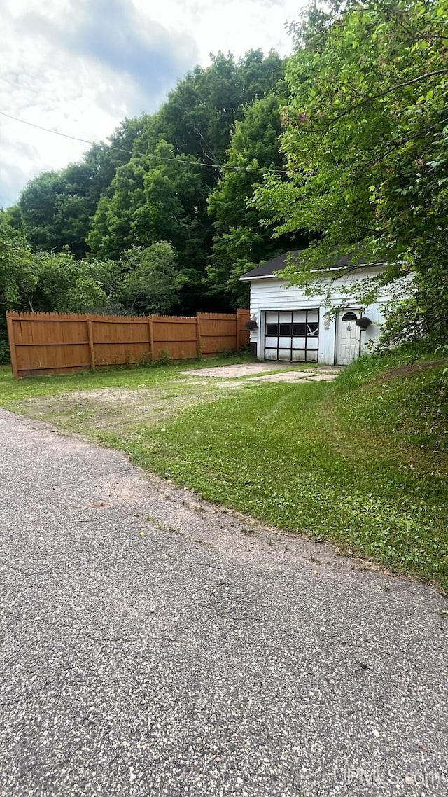 view of yard featuring an outdoor structure and fence