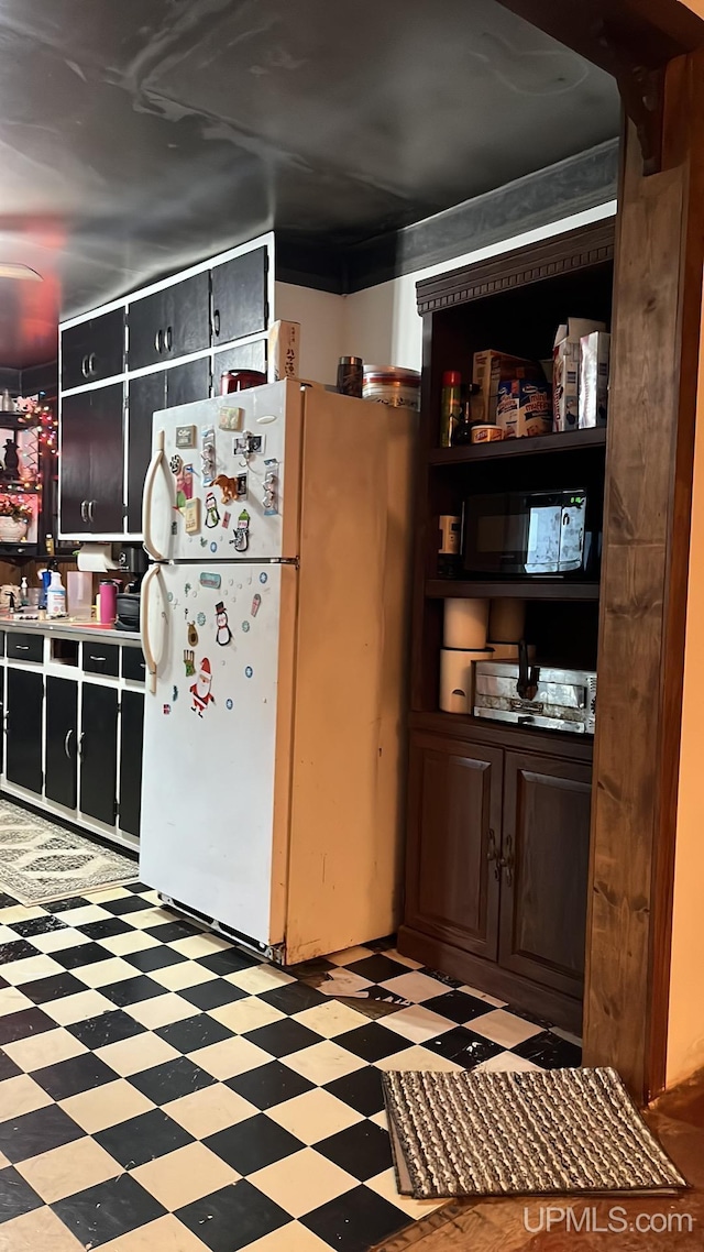 kitchen featuring light floors and freestanding refrigerator