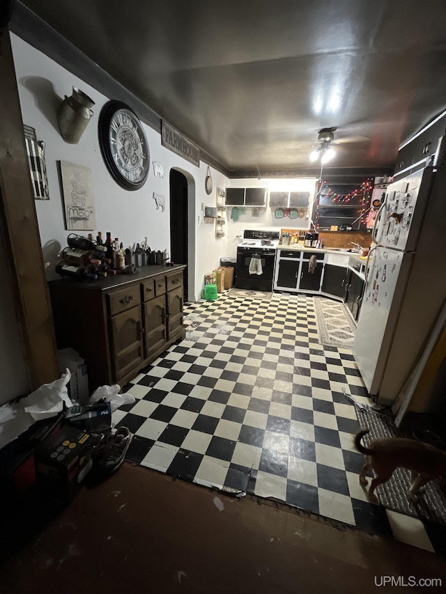 kitchen featuring ceiling fan, arched walkways, range with gas stovetop, and tile patterned floors