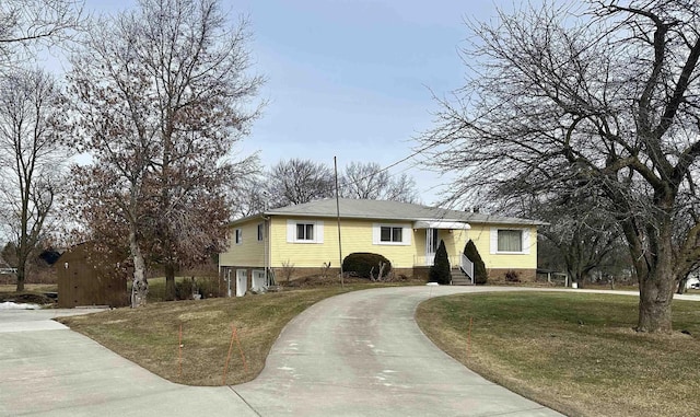 view of front of property featuring driveway and a front lawn