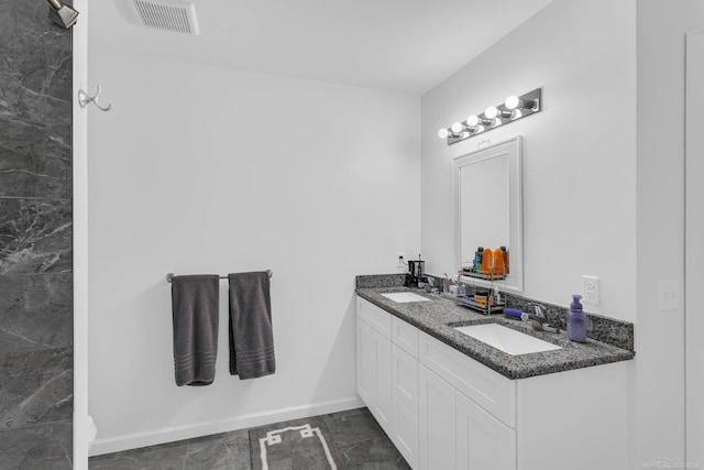 full bathroom with double vanity, baseboards, visible vents, and a sink