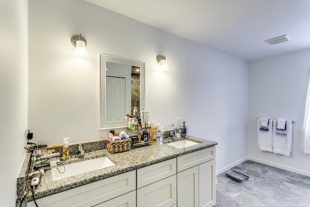 full bathroom featuring double vanity, baseboards, visible vents, and a sink