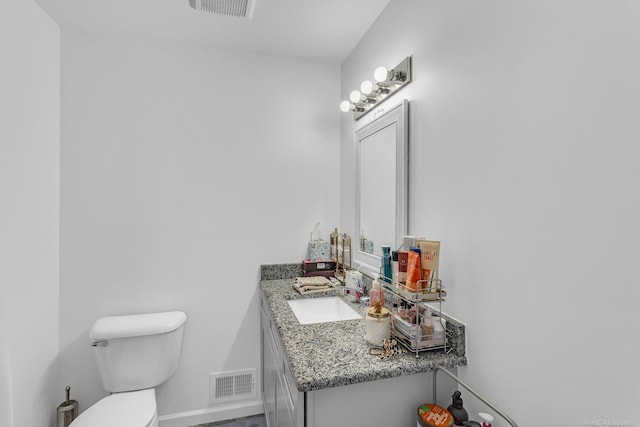 bathroom featuring baseboards, visible vents, vanity, and toilet