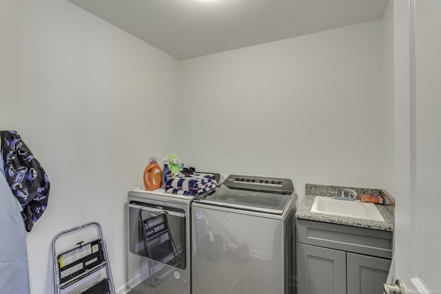 clothes washing area featuring cabinet space, a sink, and separate washer and dryer