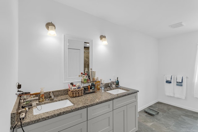 full bathroom featuring a sink, baseboards, and double vanity