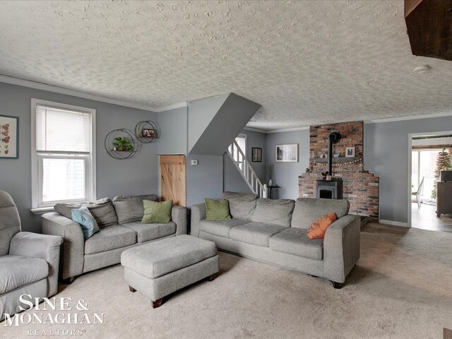 living area featuring a wood stove, carpet, ornamental molding, and a textured ceiling