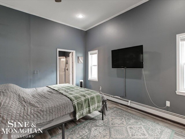 bedroom featuring a baseboard radiator, ornamental molding, and wood finished floors