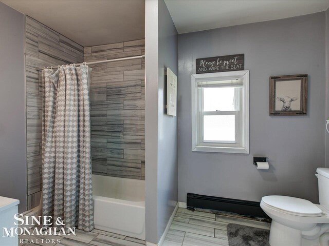 bathroom with shower / tub combo, toilet, and baseboards