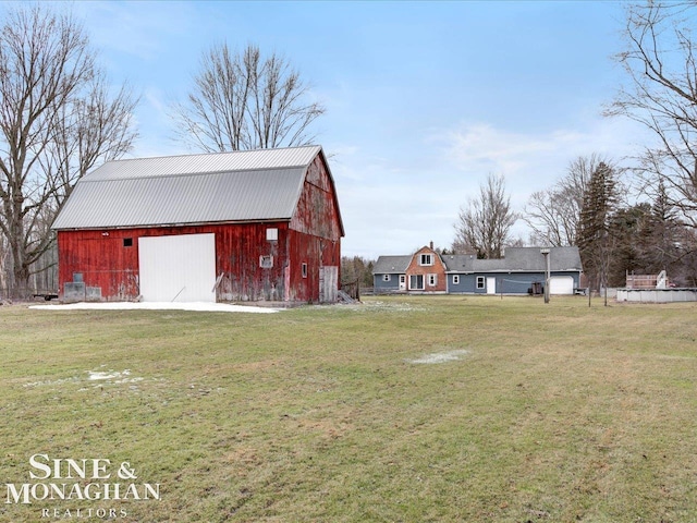 view of yard featuring a garage, an outbuilding, and a barn