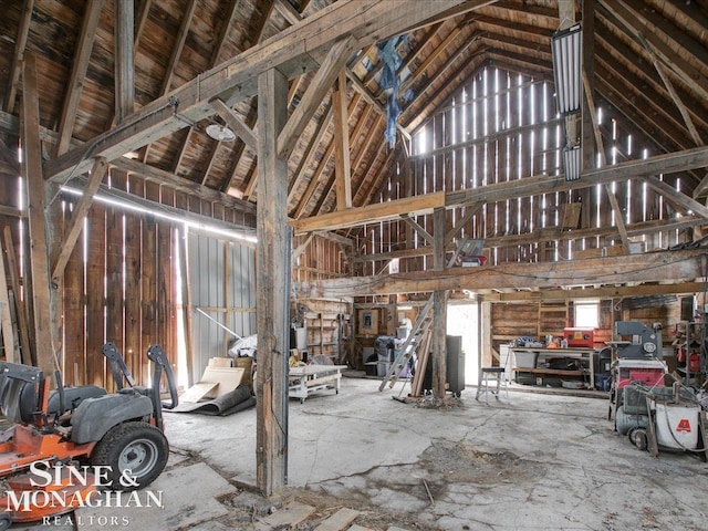 misc room with a garage and high vaulted ceiling