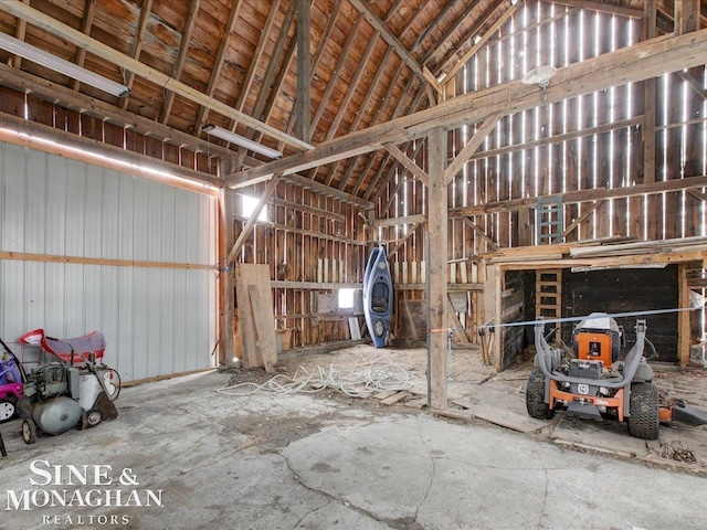 misc room with a garage, metal wall, and lofted ceiling