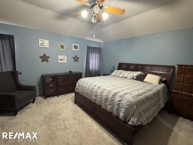 bedroom featuring lofted ceiling, light colored carpet, and ceiling fan