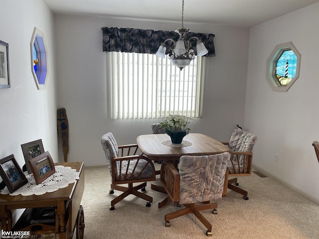 carpeted dining area with baseboards, visible vents, and a chandelier