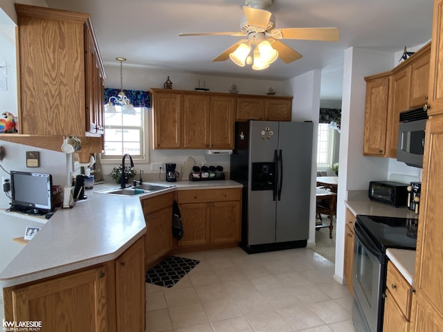 kitchen with brown cabinets, decorative light fixtures, stainless steel appliances, light countertops, and a sink