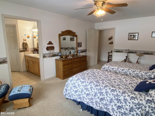 bedroom featuring a ceiling fan, a sink, and light colored carpet