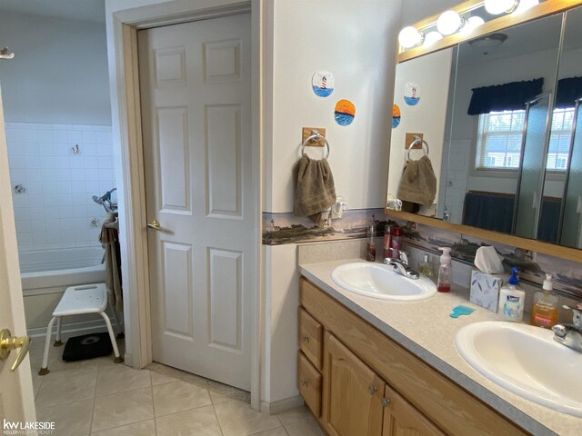 full bath featuring double vanity, a sink, and tile patterned floors