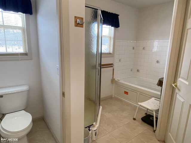 full bath featuring toilet, a stall shower, tile patterned flooring, baseboards, and a bath