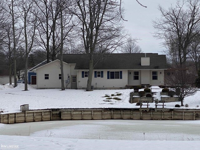 snow covered house with fence