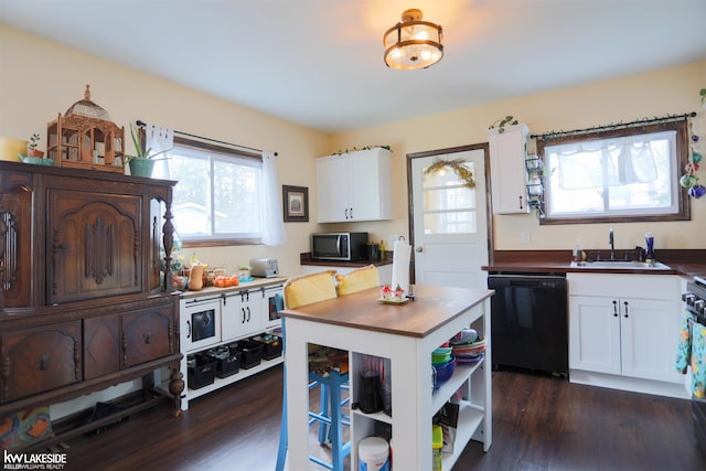 kitchen with a sink, white cabinetry, black dishwasher, dark wood-style floors, and stainless steel microwave