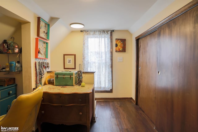 bedroom with lofted ceiling, a closet, baseboards, and dark wood-type flooring