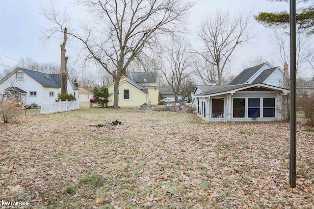 view of yard featuring a sunroom and fence