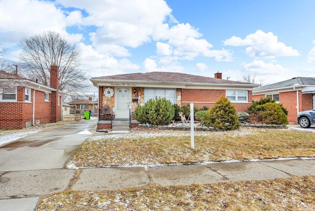 view of front of home featuring a chimney and brick siding