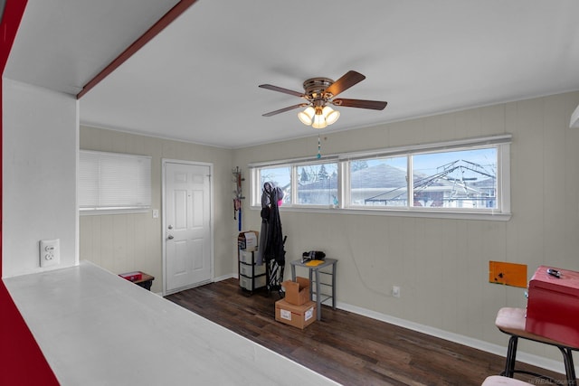 interior space featuring a ceiling fan, baseboards, and wood finished floors