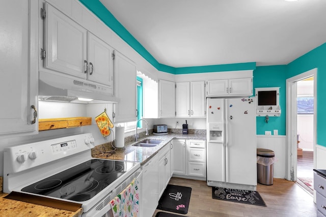 kitchen with white appliances, a sink, white cabinets, and under cabinet range hood